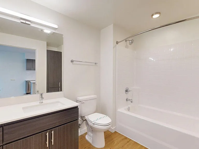 Apartment Bathroom with large soaking tub and wood-style flooring.