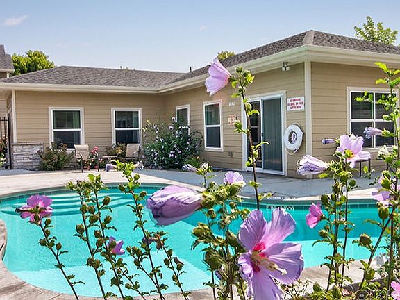 Community pool with lounge chairs, tables, and BBQ.