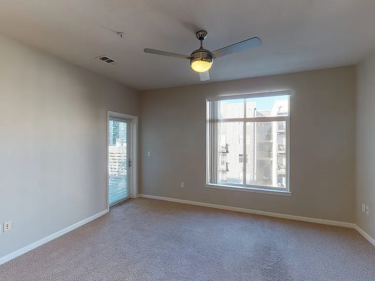 Apartment living room with plush carpet flooring with patio or balcony in select homes.