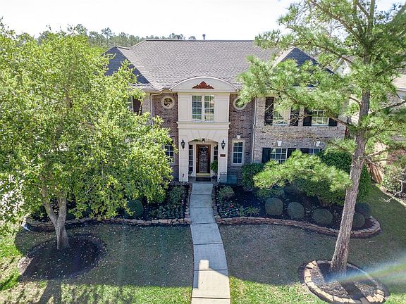 Tucked behind the trees is this stately home. Brick exterior with stucco accents, classic black shutters, light fixtures and charming windows!