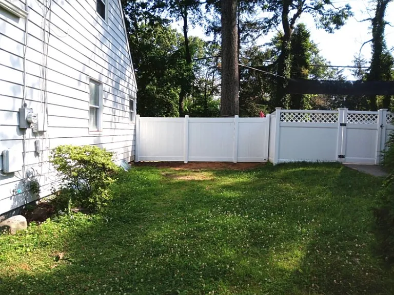 Brand new vinyl fence in fully enclosed backyard