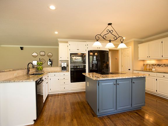 Newly refinished white cabinets coordinate beautifully with GE Profile black appliances including built in microwave, ceramic cooktop, dishwasher and oven.