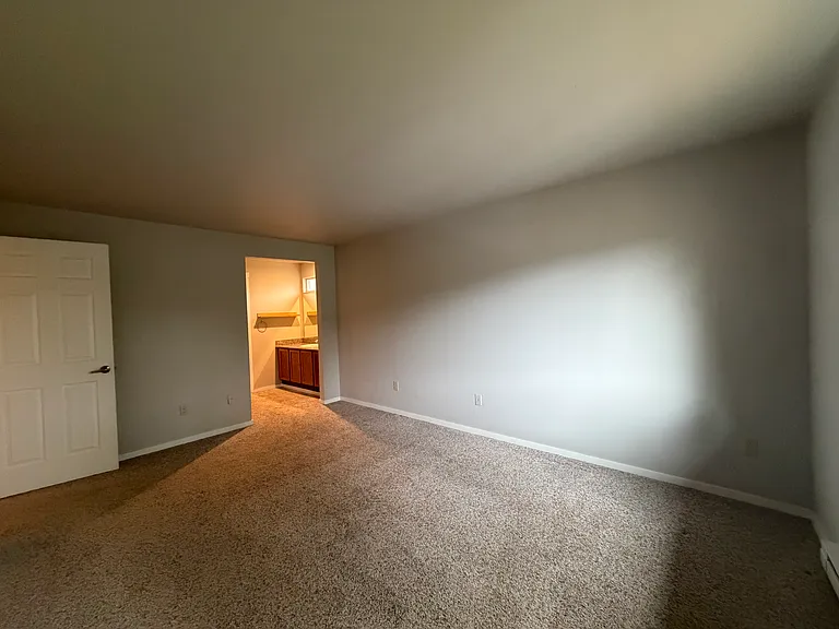 large primary bedroom with room for king bed, night stands, dresser and desk