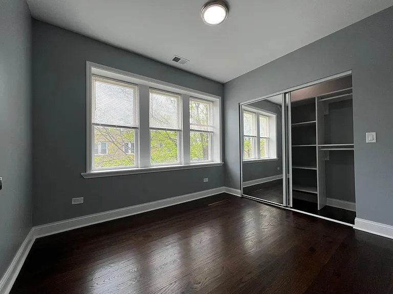 2nd bedroom with built-in organizer closet and mirrored doors.