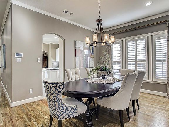 The dining room between the kitchen and living room has crown moulding, recessed lighting, and a beautiful wall of windows with custom Plantation shutters.
