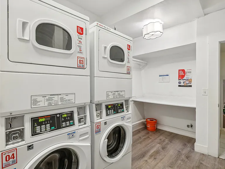 Laundry room with washing machines neatly arranged on a wooden floor