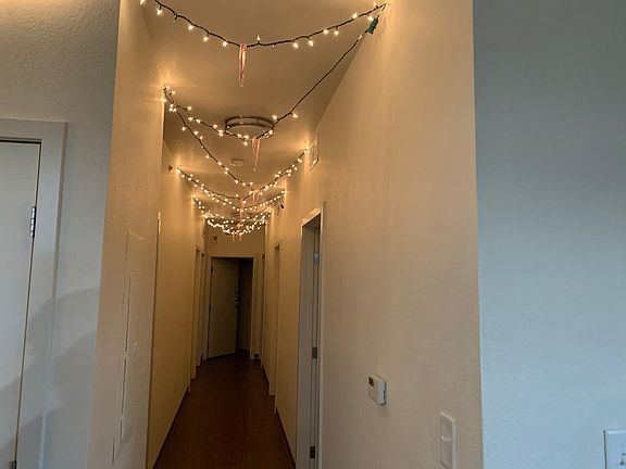 hallway with the 3 rooms on the right side and the 3 personal bathrooms on the left. at the end of the hall there is the "deluxe" room with the bedroom and bathroom behind that door.