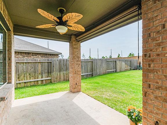 The covered back patio has a fan and pull-down shades on two sides.