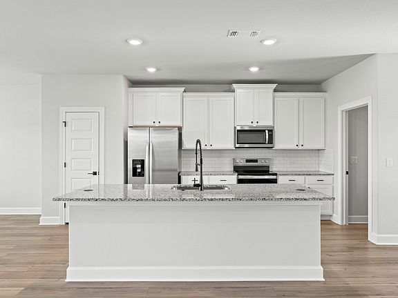 The kitchen has beautiful white cabinetry.