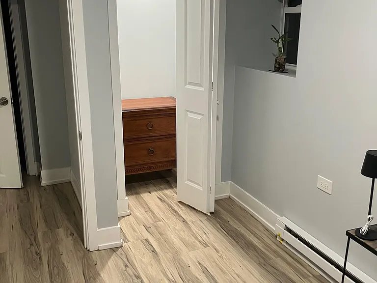 Bedroom with durable plank flooring, a window nook for natural light, and a closet for convenient storage.