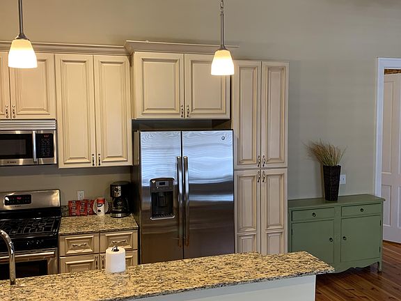 Solid wood cabinetry including 4 door multiple shelved pantry, pendant lights at breakfast bar