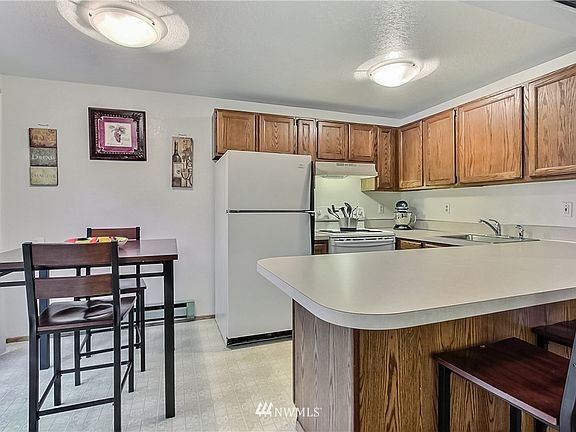 View of kitchen with included appliances and dining area. 