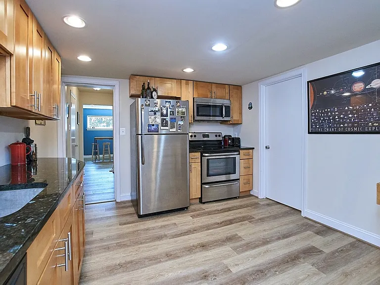 Renovated kitchen with newer cabinets, stainless steel appliances, uba tuba granite counters and luxury vinyl plank floors.