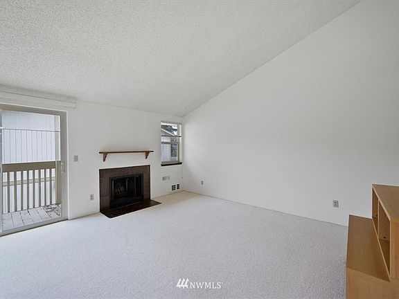 Vaulted ceiling living room with fireplace. Sliding door leading to deck.
