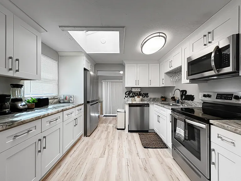 Kitchen
Updated kitchen with crisp white cabinets, stainless steel appliances, and generous counter space. Clean, modern, and built for everyday cooking.