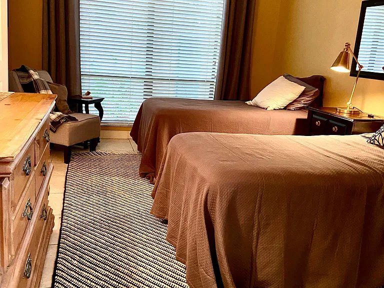 Second bedroom or middle bedroom with dresser chair large window for natural light