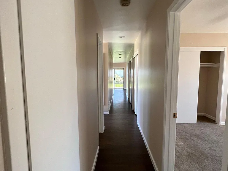 Hallway connecting bedrooms with 2 large closets.