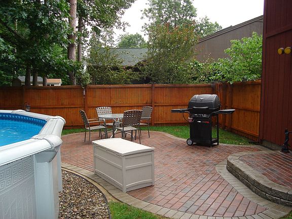 Private fenced yard with brick paver patio and aboveground pool