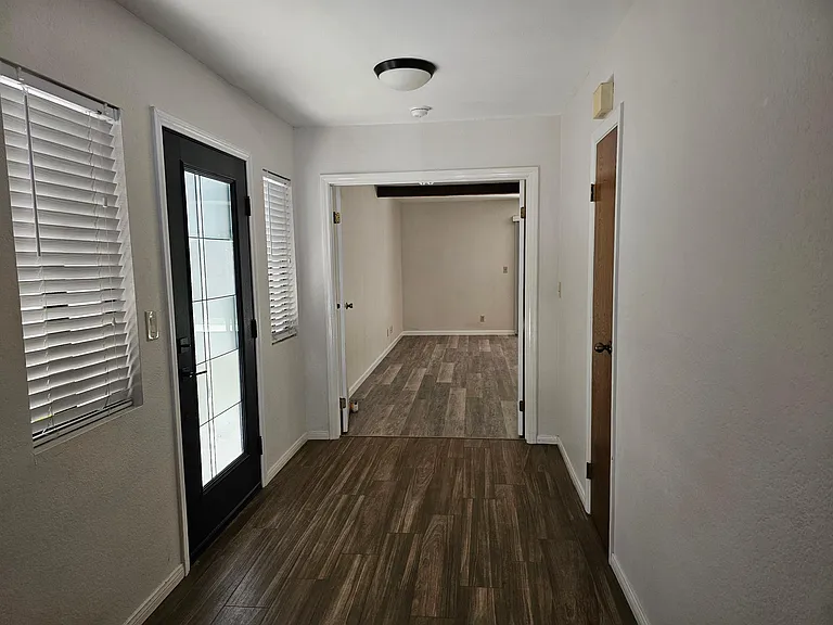 Side entry door and looking into master bedroom with double doors..
