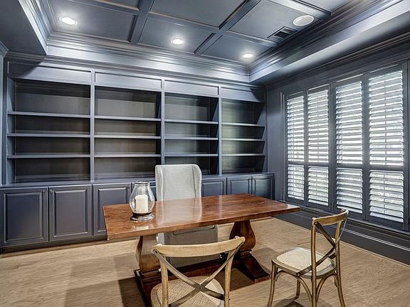 [Study]The impressive study flanks the double-height foyer and features a natural hardwood floor, coffered ceiling, and a wall of book/display cabinets with a media shelf.