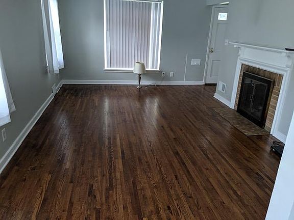 Refinished hardwood floors, white enamel trim, and working fireplace in the living room.