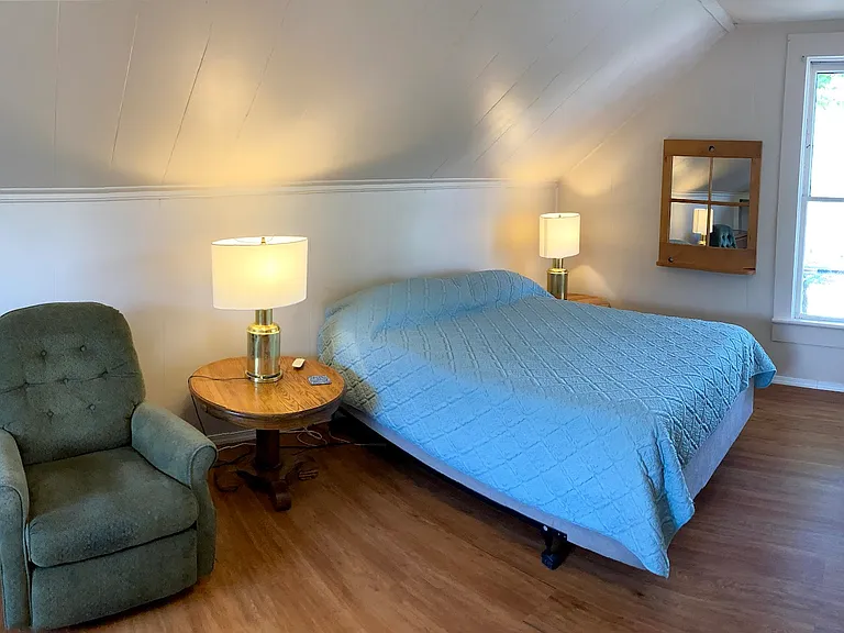 This upstairs bedroom is over the living room. This is the view to the west with window overlooking the 135 year elm tree.