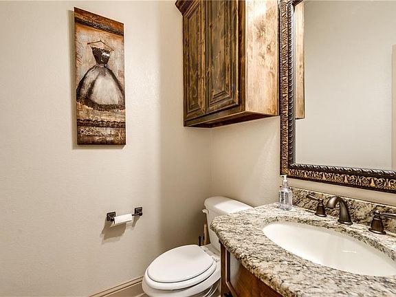 Powder bathroom located on the first floor complete with granite counters and elegant mirror.