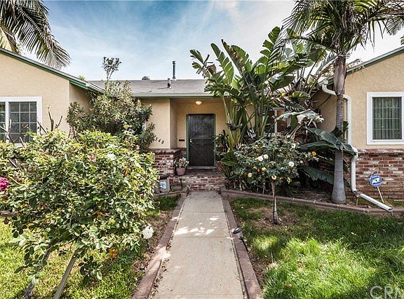 Enter the front gate into a lovely front yard that even has an apple tree!