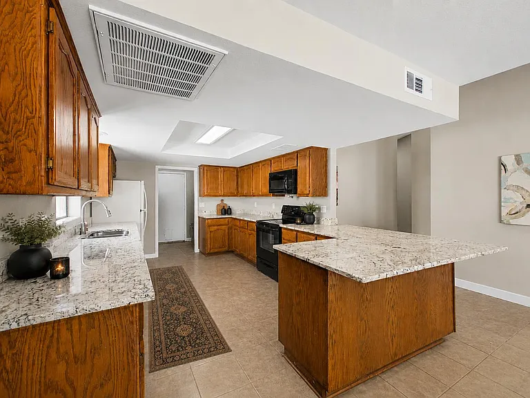 Spacious kitchen with ample wood cabinetry, generous counter space, and a large island for prep and casual dining.