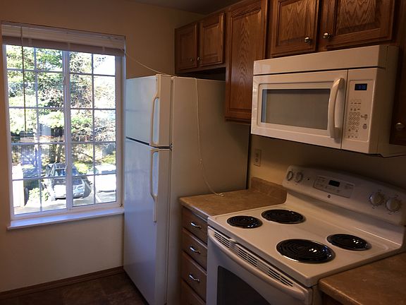 Kitchen with electric range. Microwave over stove and refrigerator.