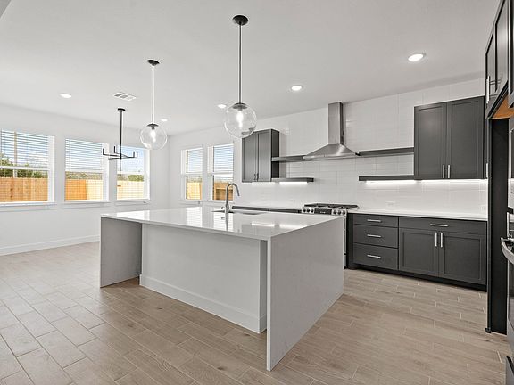 Kitchen featuring island with waterfall-edge countertop