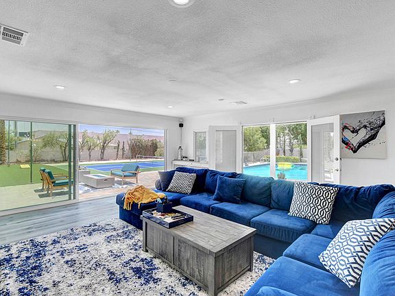 Lounge with large sliding doors that lead into the backyard with the pool, cabanas, pickleball court and huge artificial grass area.