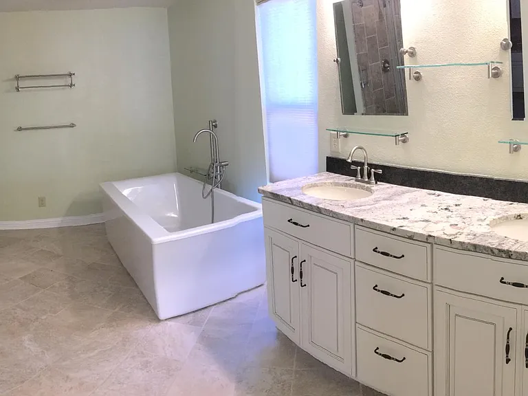 Master bathroom with 6' tub, Travertine tiled on floors and shower, granite counters, upscale shower door, hardware, faucets, mirrors and shelves.