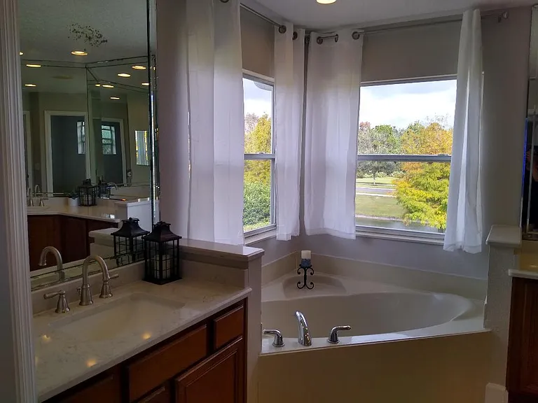 Master bathroom with dual sinks and bathtub