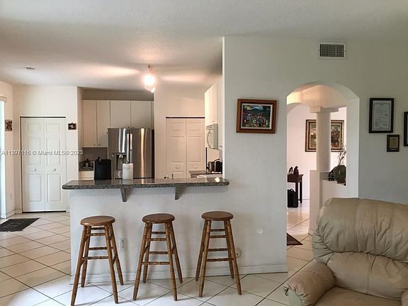 Here is the view from the Familyroom looking into the kitchen. If you look carefully you can see on the left the opening to the sliding glass doors that open into the outdoor patio. To the right you can see the architectural details of columns that greet 