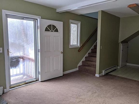 Entry way, living room, and stairs leading up to bedroom