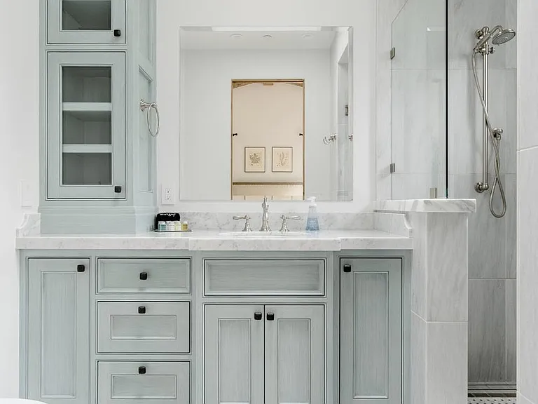 master vanity with all marble counter, floor, tower cabinets, sky light