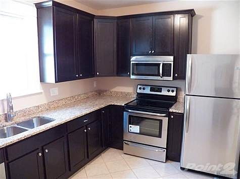 Kitchen with new stainless appliances and refrigerator