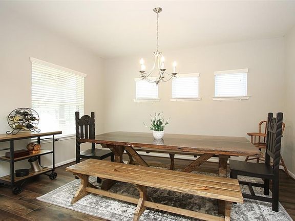This Formal Dining offers lots of light from a front facing window and triple transom windows with custom blinds. The pretty chandelier elevates this space as well as recently installed wood laminate flooring.
