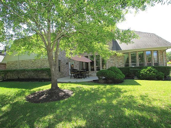 A large shade tree sits near the back patio for a beautiful setting in the back yard.