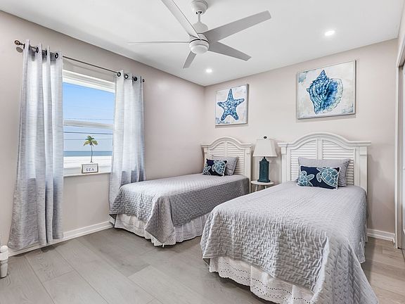 guest bedroom with 2 twin beds that also has a view of the beach