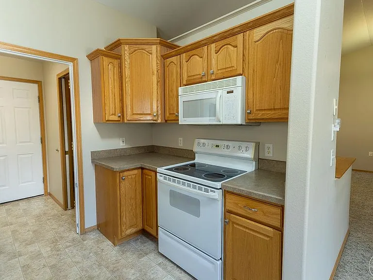 Electric smooth top stove, microwave. Door to garage to the left, with door to half bath