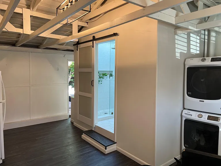 View of bonus room with entry to bathroom 2 and new washer and dryer set and back patio door