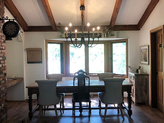 Dining area with bay window and built in desk area with shiplap and decorative vintage corbels
