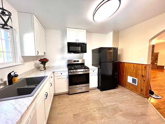 Spacious kitchen with new appliances and window looking out on back yard.