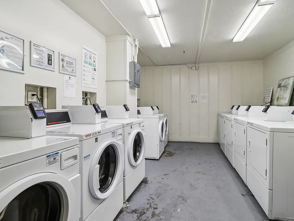 Laundry room with washing machines neatly arranged on a wooden floor