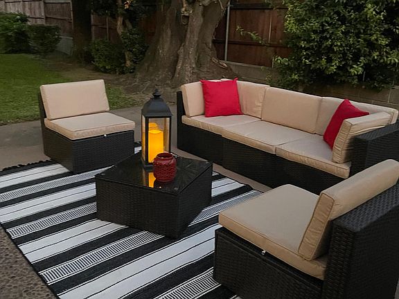 Outdoor seating and dining tables with bistro umbrellas and lights