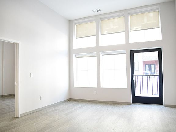 A room with a black door and a balcony.