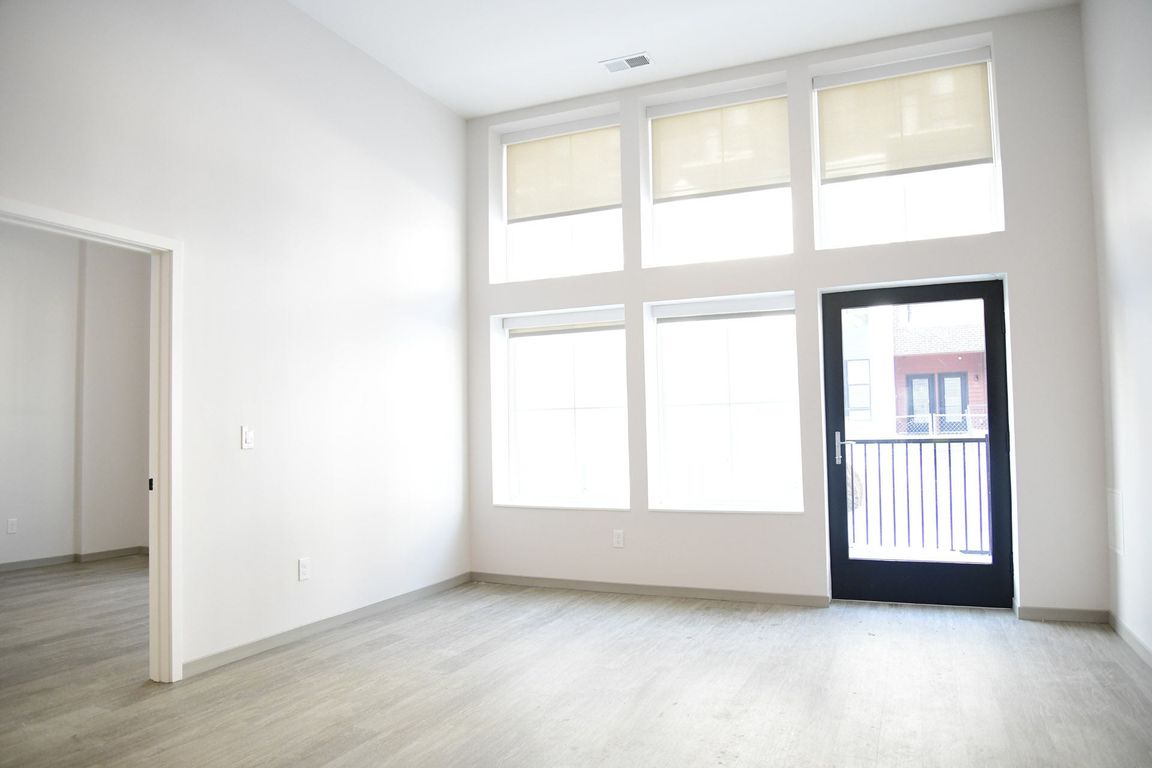 A room with a black door and a balcony.