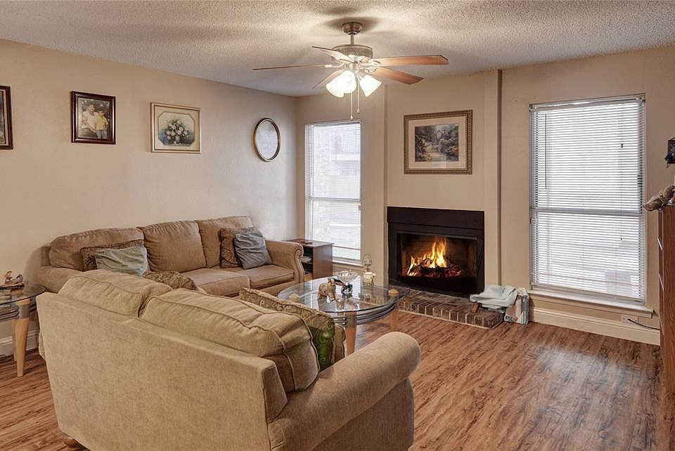 ANOTHER VIEW OF THE LIVING ROOM WITH WOOD-BURNING FIREPLACE